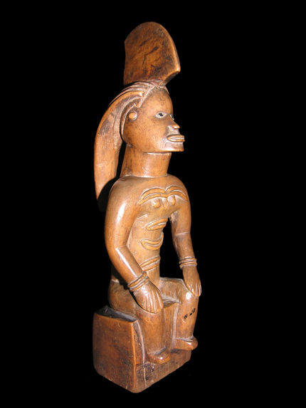 Statuette masculine assise avec haute coiffe en cimier et tresse à l’arrière