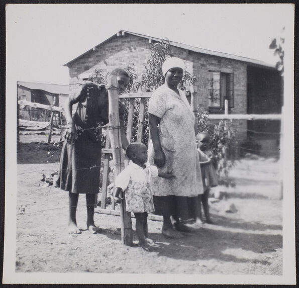 Sans titre [femmes et enfants à côté d'habitations]