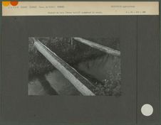 Conduit de bois (tronc taillé) enjambant le canal