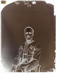 Rakai-ben-Bazis [Portrait de face d'un homme assis sur une chaise]