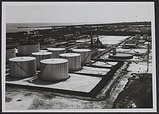 Sans titre [Vue aérienne des cuves d'une usine au bord de la mer]