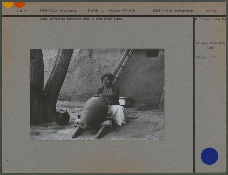 Femme assyrienne barattant dans la cour d'une ferme