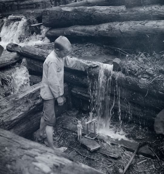 Jeune garçon jouant avec un moulin à eau