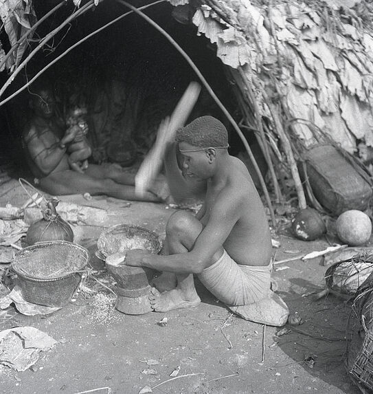 Sans titre [Jeune femme préparant le repas devant sa hutte]