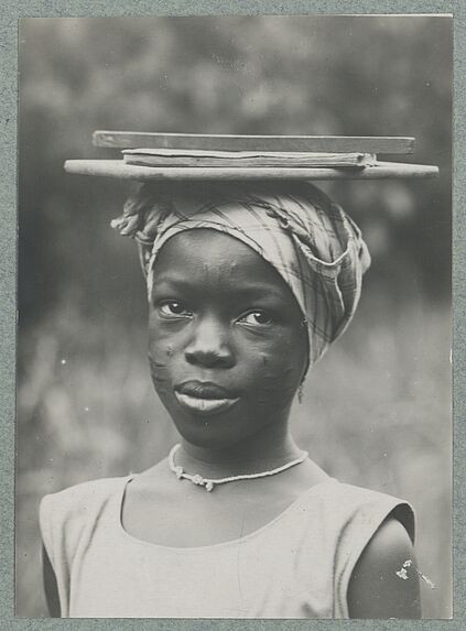 Ecolière de Natitingou portant des fournitures sur la tête