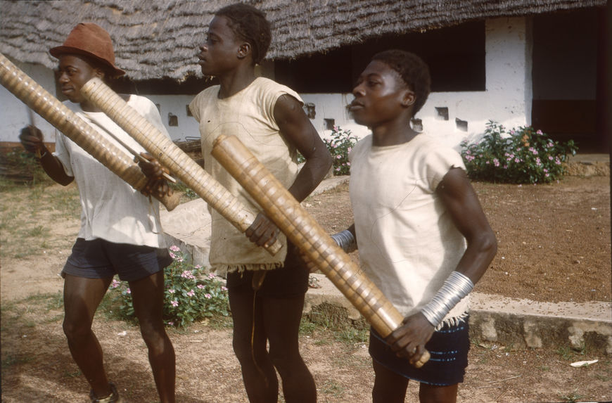 Ifan, en brousse [trois jeunes hommes avec des instruments à percussion]