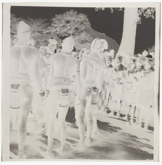Femmes nues avec leurs bijoux rituels [rangées de jeunes gens en tenue de cérémonie]
