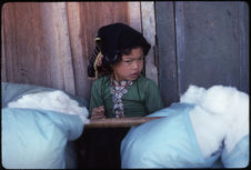 Petite fille gardant les balles de coton au marché de Dien Bien Phu