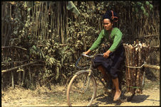Jeune femme à bicyclette transportant du bois