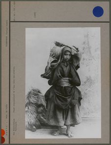 Femme transportant de l'eau dans une poterie