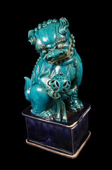 Lion de Fô, céramique bleu-vert, sur socle rectangulaire violet, tenant une…