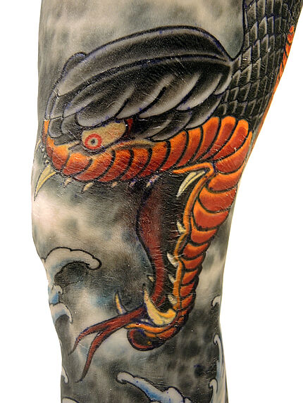 Volume tatoué de style japonisant sur une jambe de femme