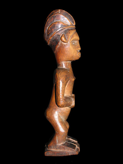 Statuette féminine debout mains sur l’abdomen et coiffure en 5 coques