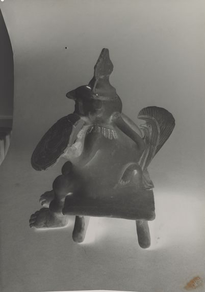 Personnage assis en céramique sur un siège, avec casque et bouclier