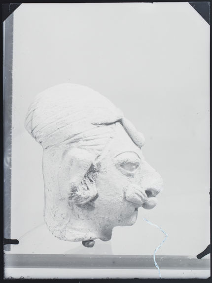 Tête humaine à crâne déformée en céramique grise