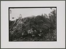 Vieille Fuégienne et deux enfants près d'une hutte